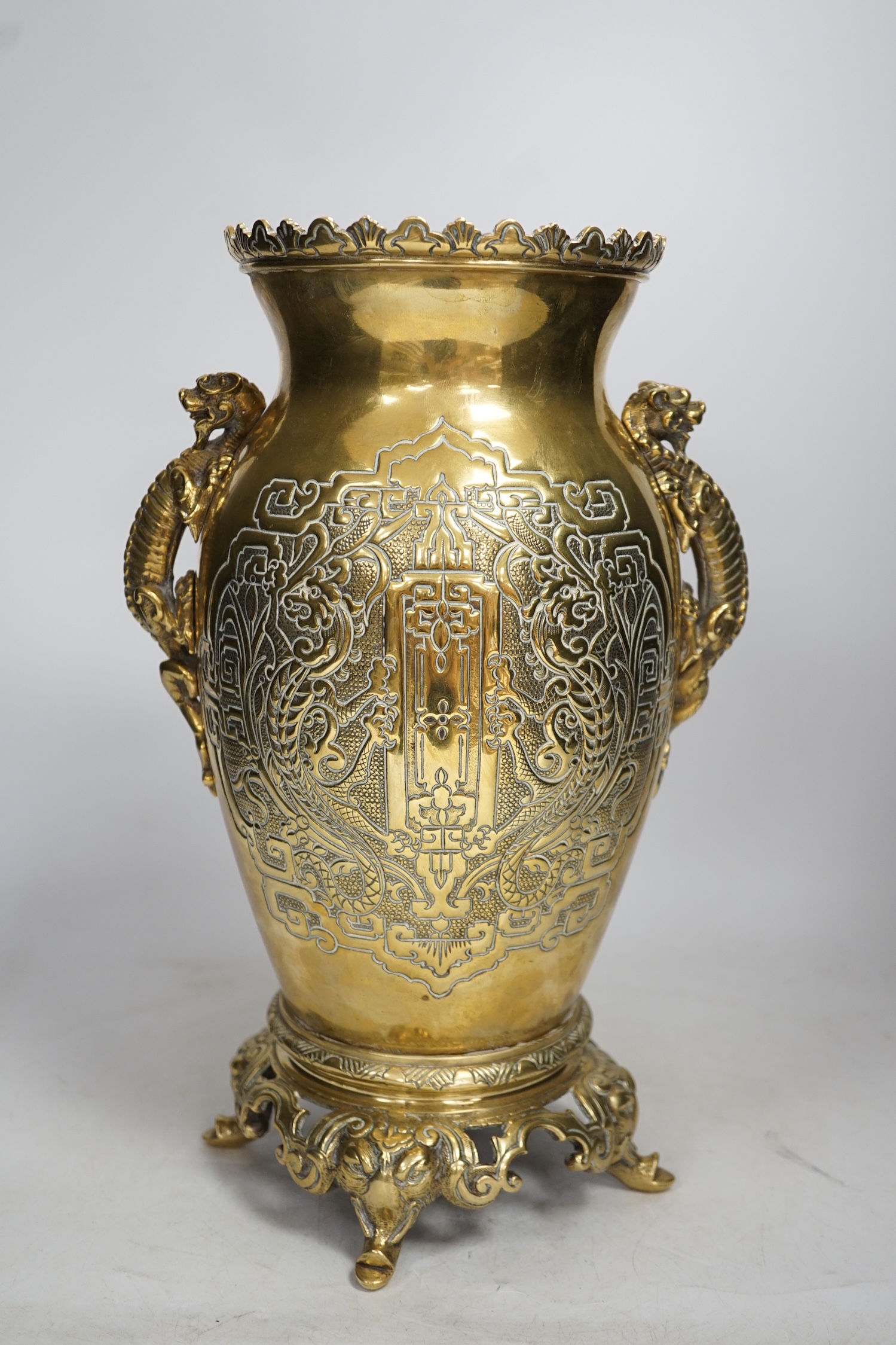 A Chinese dragon handled brass vase with ornate stand, 34cm high. Condition - the base to vase is missing